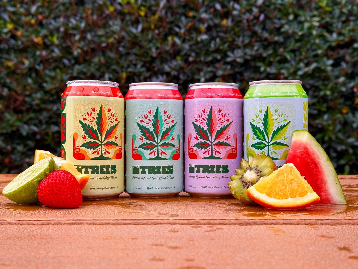 4 vibrantly colored cans with fruit, THC beverages called Little Trees